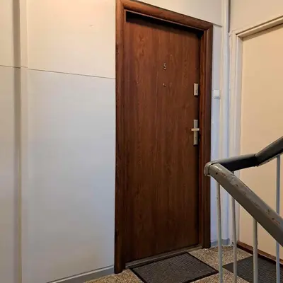 a wooden door in a room with a staircase at Apartament Słowackiego in Oświęcim