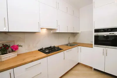a white kitchen with white cabinets and a stove at Apartament Słowackiego in Oświęcim