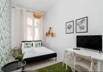 a white living room with a bed and a desk at Main Square Heaven Apartment in Kraków