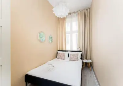 a bedroom with a white bed with a window at Main Square Heaven Apartment in Kraków