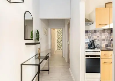 a kitchen with a glass table and a hallway at Main Square Heaven Apartment in Kraków