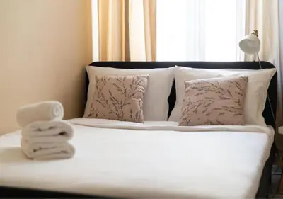 a white bed with towels on it with a window at Main Square Heaven Apartment in Kraków