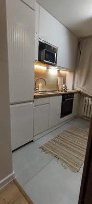 a kitchen with white cabinets and a sink at SmartApart in Kraków