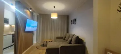 a living room with a couch and a flat screen tv at SmartApart in Kraków