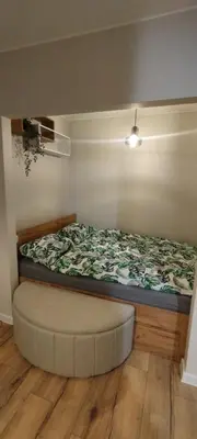 a bed with an ottoman in a room at SmartApart in Kraków