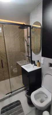 a bathroom with a shower and a toilet and a sink at SmartApart in Kraków
