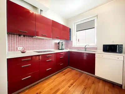 a kitchen with red cabinets and a window at Apartment in cozy area for 4 guest, Cracow in Kraków