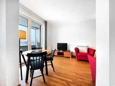 a living room with a table and a red couch at Apartment in cozy area for 4 guest, Cracow in Kraków