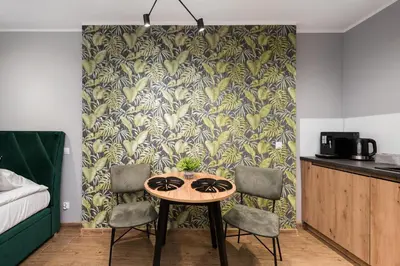 a table and chairs in a room with a wall at Underground Apartments by BookingHost in Kraków