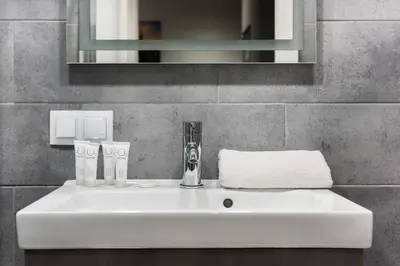 a white sink in a bathroom with a mirror at Underground Apartments by BookingHost in Kraków