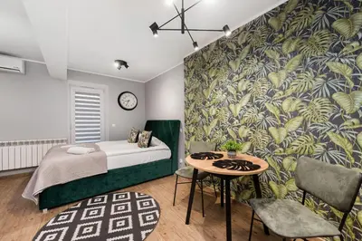 a bedroom with a bed and a table with a clock at Underground Apartments by BookingHost in Kraków