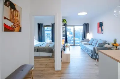 a kitchen and living room with a couch and a bed at Balloon View Apartment in Kraków