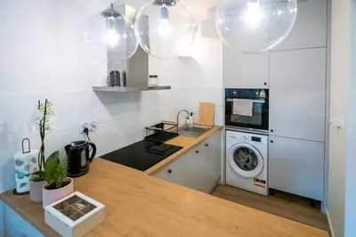 a kitchen with a sink and a washing machine at Balloon View Apartment in Kraków