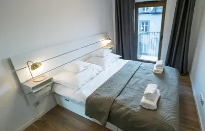 a bedroom with a bed with two towels on it at Balloon View Apartment in Kraków