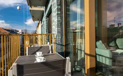 a table on a balcony with a cup of coffee on it at Balloon View Apartment in Kraków