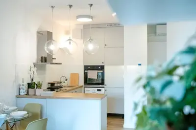 a kitchen with white cabinets and a counter top at Balloon View Apartment in Kraków