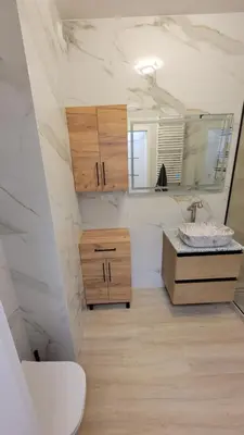 a bathroom with a sink and a toilet and a mirror at Illumina nowoczesny apartament 50m2, spokojna okolica, 25min do centrum in Kraków