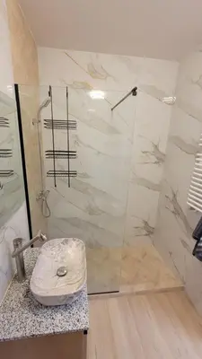 a bathroom with a shower and a sink at Illumina nowoczesny apartament 50m2, spokojna okolica, 25min do centrum in Kraków