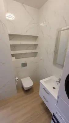 a white bathroom with a toilet and a sink at Illumina nowoczesny apartament 50m2, spokojna okolica, 25min do centrum in Kraków