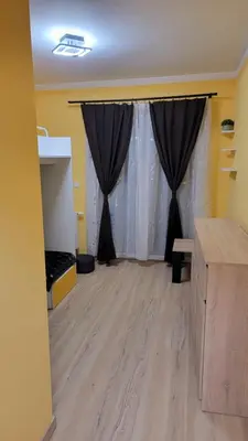 a room with black curtains and a wooden floor at Illumina nowoczesny apartament 50m2, spokojna okolica, 25min do centrum in Kraków