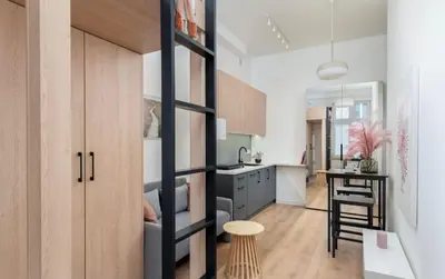 a kitchen with a ladder leading to a living room at Lumi Loft Kraków in Kraków