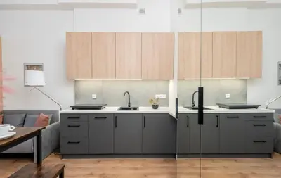 a kitchen with gray cabinets and a glass wall at Lumi Loft Kraków in Kraków