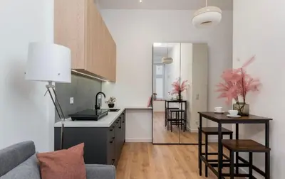 a kitchen and living room with a couch and a table at Lumi Loft Kraków in Kraków