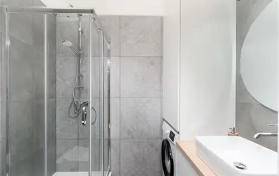 a bathroom with a shower and a sink at Lumi Loft Kraków in Kraków
