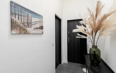 a vase with feathers on a table in a room at Lumi Loft Kraków in Kraków