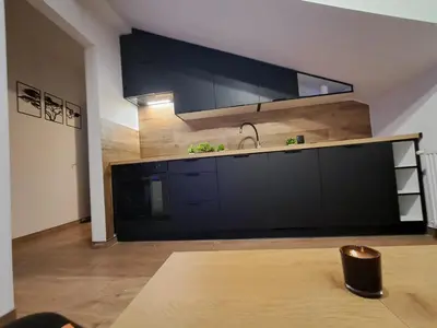 a kitchen with black cabinets and a sink at Zaskawie Apart in Wadowice