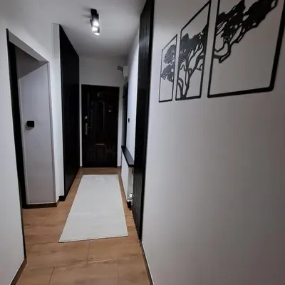 a hallway with black and white walls and a white rug at Zaskawie Apart in Wadowice