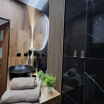 a bathroom with a black sink and a mirror at Zaskawie Apart in Wadowice