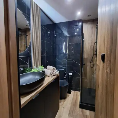 a black bathroom with a sink and a shower at Zaskawie Apart in Wadowice