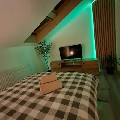 a bedroom with a bed and a tv on a dresser at Zaskawie Apart in Wadowice