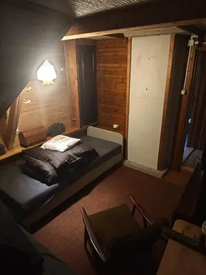 a bedroom with a bed and a table in a room at oBłędny Domek in Zawoja