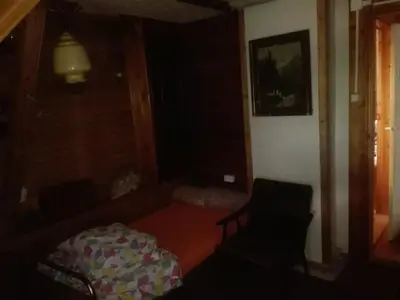 a living room with a couch and a chair at oBłędny Domek in Zawoja