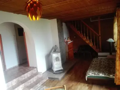 a living room with a fireplace and a staircase at oBłędny Domek in Zawoja