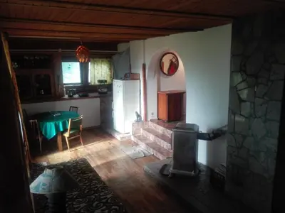 a kitchen with a stove and a table in a room at oBłędny Domek in Zawoja