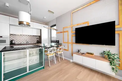 a kitchen with a flat screen tv on a wall at Apartment with private terrace by NEARTO PL in Kraków
