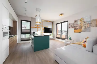 a living room with a couch and a kitchen at Apartment with private terrace by NEARTO PL in Kraków
