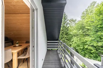 a house with a staircase leading up to a deck at Zielone Wzgórze- domki całoroczne Zawoja in Zawoja