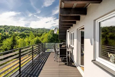 a balcony of a house with a view of the mountains at Zielone Wzgórze- domki całoroczne Zawoja in Zawoja