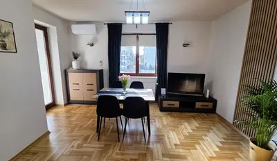 a living room with a couch and a table and a mirror at Apartament GOLD blisko Wawelu z DARMOWYM PARKINGIEM in Kraków