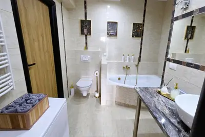 a bathroom with a tub and a toilet and a sink at Apartament GOLD blisko Wawelu z DARMOWYM PARKINGIEM in Kraków