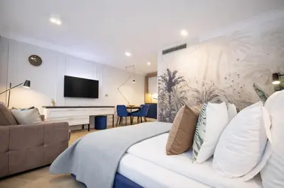 a bedroom with a bed and a couch and a tv at InPoint Central Apartments in Kraków