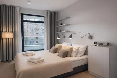 a bedroom with a large bed with towels on it at InPoint Central Apartments in Kraków