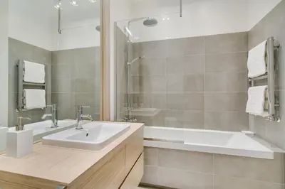 a bathroom with a sink and a shower and a tub at InPoint Central Apartments in Kraków