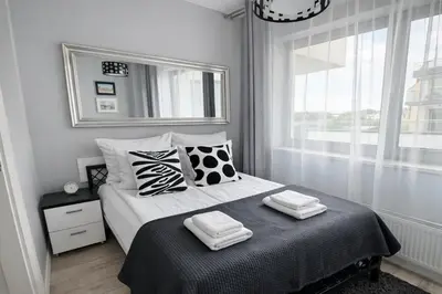 a bedroom with a bed with two towels on it at InPoint Central Apartments in Kraków