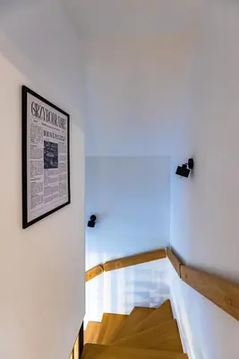 a stairwell in a house with a newspaper on the wall at Domki Gasiówka in Jaworzna