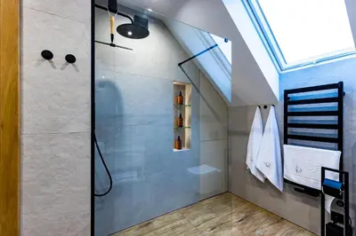a shower with a glass door in a bathroom at Domki Gasiówka in Jaworzna